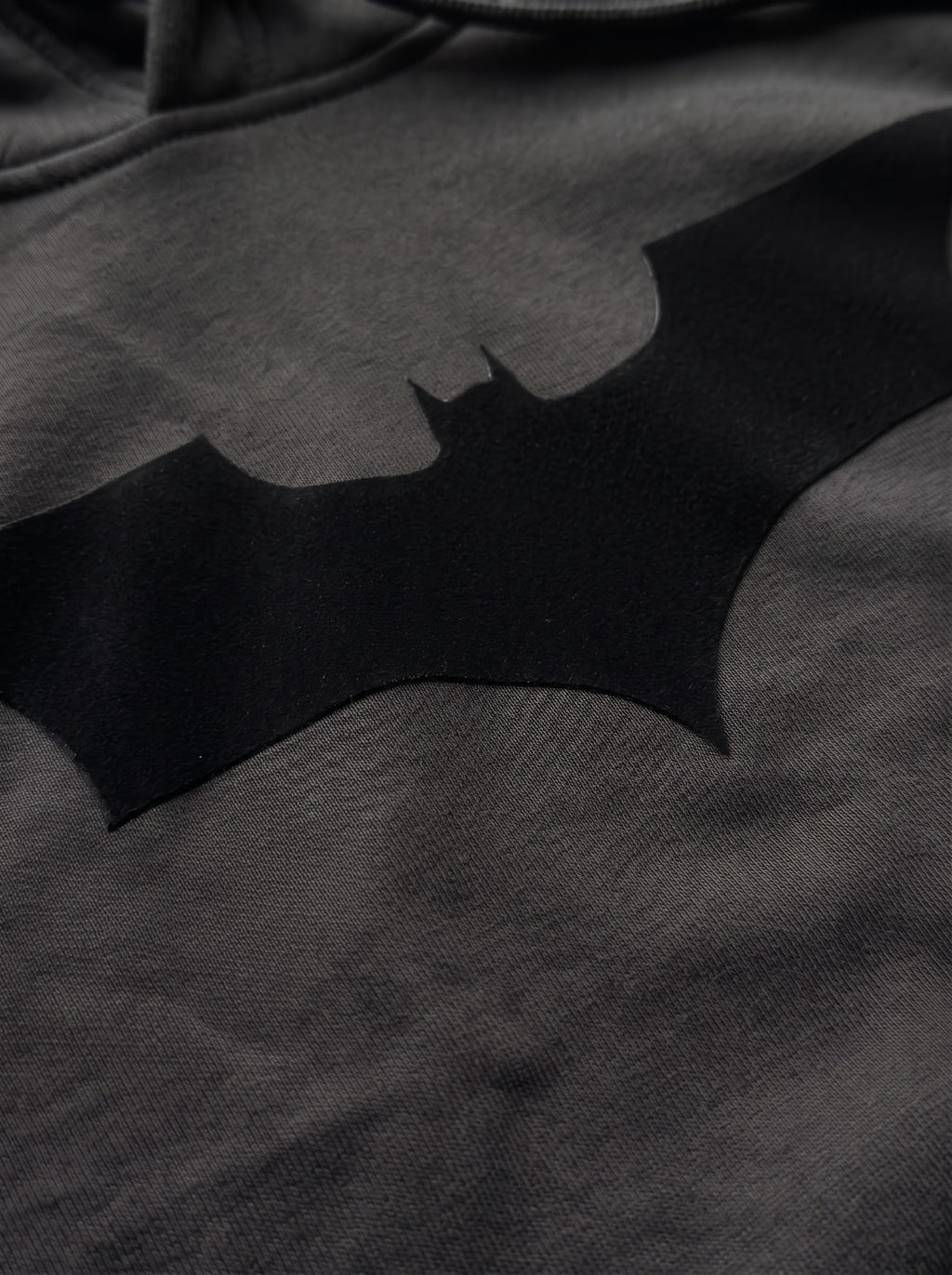 Close-up of the black Batman emblem flock print on the IRON CULT Dark Knight Hoodie