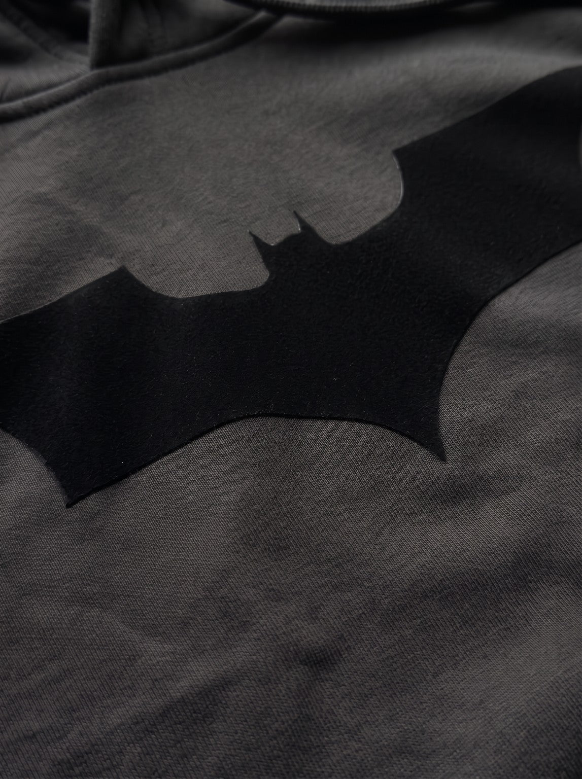 Close-up of the black Batman emblem flock print on the IRON CULT Dark Knight Hoodie